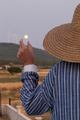 the villager woman wearing wicker hat hold the moon.