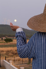 the villager woman wearing wicker hat hold the moon.