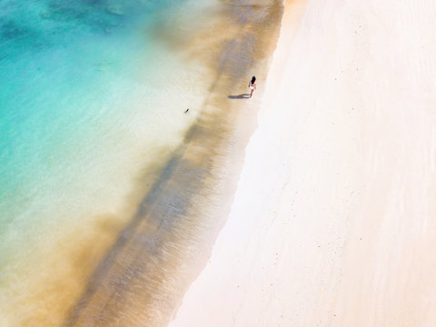 Woman walking alone on an empty beach in Malaysia