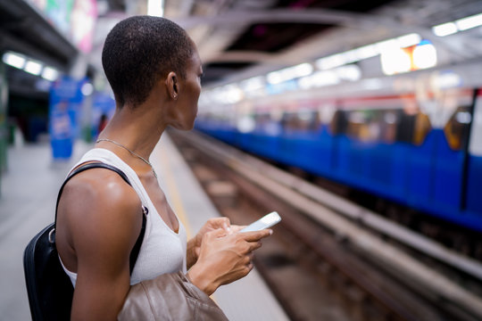 Woman checking train arrival times on her phone