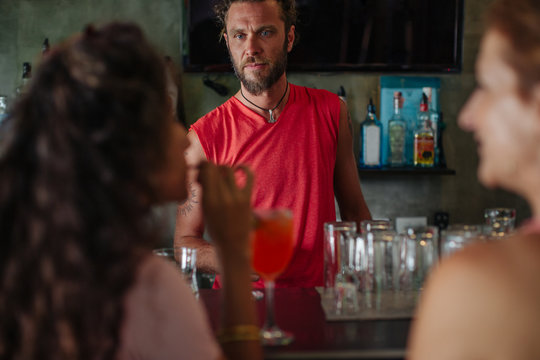 Two girlfriends ordering a drink at a bar