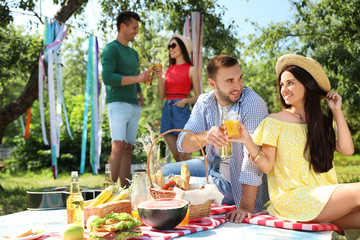 Young people enjoying picnic in park on summer day