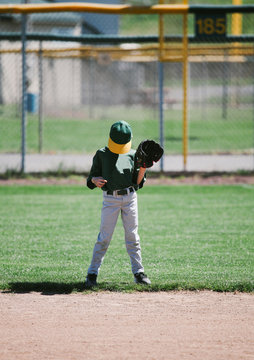 young ballplayer preoccupied out on the baseball field
