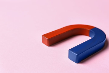 Red and blue horseshoe magnet on pink background