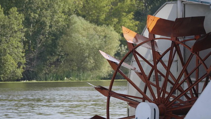 Red Riverboat Paddle Wheel in a River with Trees
