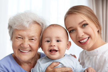 Happy young woman with her child and grandmother at home
