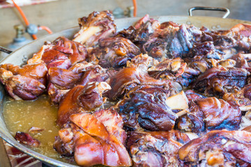 Roast meat pieces in a paella dish.