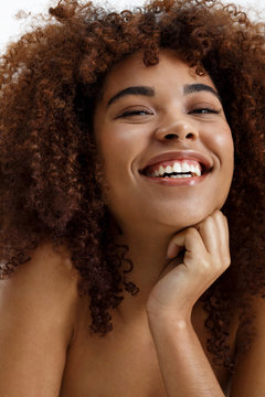 African American woman nude portrait smiling naturally over white background