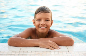 Happy cute boy in swimming pool
