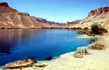 Band-e Amir lakes near Bamyan (Bamiyan) in Central Afghanistan. Band e Amir was the first national park in Afghanistan. View with reeds from the shore of a natural blue lake at Band e Amir Afghanistan