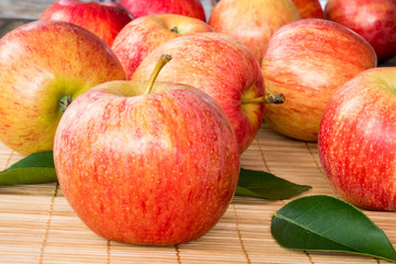 Red and pink apples with  green leaves  , close up