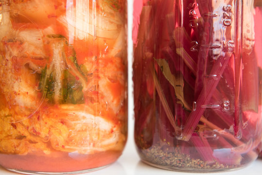 Jars of fermenting kimchi and pickled beet stems