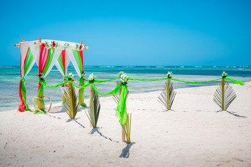 Fototapeta na wymiar Wedding archway are arranged on the sand in preparation for a beach wedding ceremony.