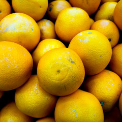 Background from oranges in the market. Ripe fruits on the counter.
