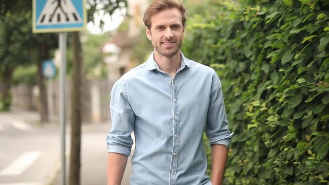 excited young casual man celebrates succeess while showing blank speech bubble and walking