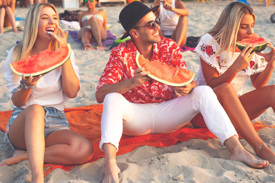 Friendship. People on the beach. Young hipster people eating watermelon on the beach. 