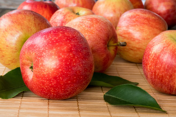 Red and pink apples with  green leaves  , close up