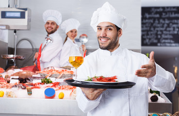 chef with dishes on serving tray welcoming