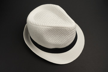 Белая шляпа на черном фоне