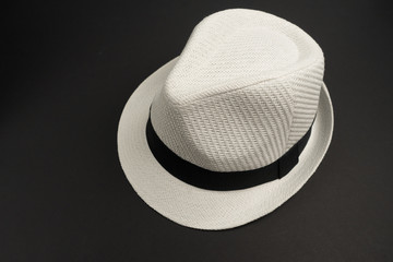 Белая шляпа на черном фоне