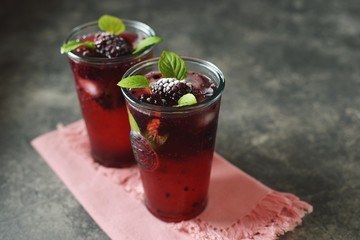 Blackberry mojito with mint, ice and frozen berries.