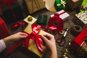Fototapeta na wymiar Gift wrapping. Woman packs holiday gifts at home.