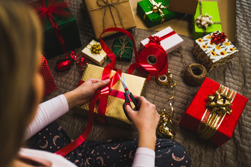 Gift wrapping. Woman packs holiday gifts at home.