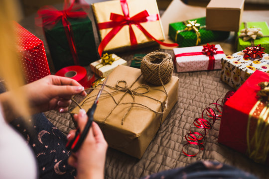 Gift wrapping. Woman packs holiday gifts at home.