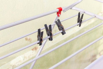 A rack dryer stands outside on a sunny day to dry white clothes. Foldable clothes dryer.