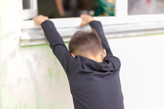 children crawl out the window from the street wants to get home