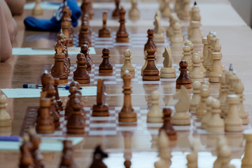 Chess, Board game. The game concept. Developing the abilities of using old games. People of different ages playing at the tables in rapid chess