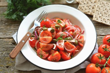Cherry tomato salad with red onions, capers and dill, with olive oil, soy sauce and wine vinegar dressing. Healthy food.