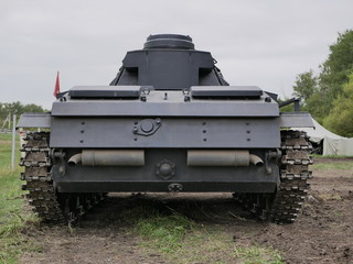 Fototapeta premium German medium tank of the Second World war in working order. the tank is painted black against a background of green trees in summer .
