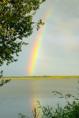a colorful rainbow over the lake during a thunderstorm
