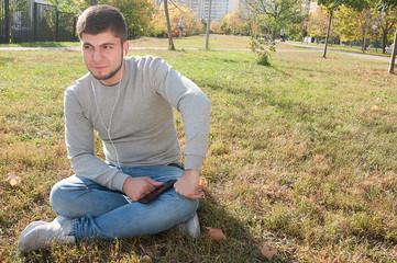 Obraz premium guy relaxes in the park, relaxes, listens to music