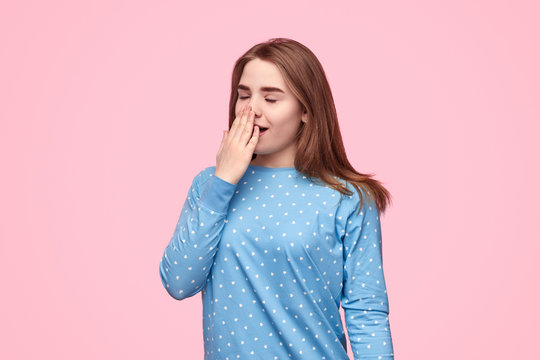 Sleepy Teen Girl Yawning And Covering Mouth