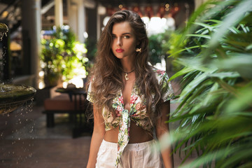 Beautiful woman posing in the yard with the fountain