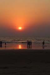 people on the background of an orange sunset in GOA