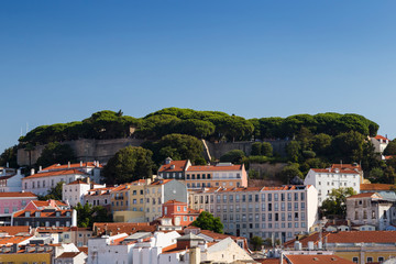 Fototapeta na wymiar View of Sao Jorge Castle (Saint George Castle, Castelo de Sao Jorge) and old buildings at the historical Alfama district in downtown Lisbon, Portugal, on a sunny day in the summer. Copy space.