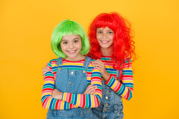 Freedom for expression. Fantasy hair trend. Sisters having fun. Semi permanent color cream. Colored clip in hair extensions. Change color. Kids girls with vibrant hairstyle. Pigment dye hair