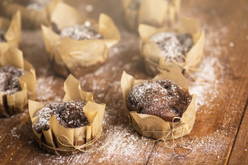 Tasty chocolate muffins in powdered sugar