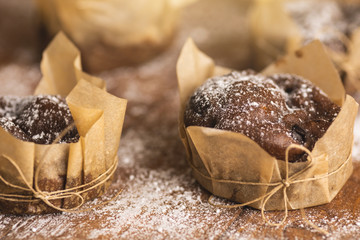 Tasty chocolate muffins in powdered sugar