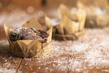 Tasty chocolate muffins in powdered sugar
