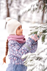 cheerful girl having fun at winter snow forest outdoor