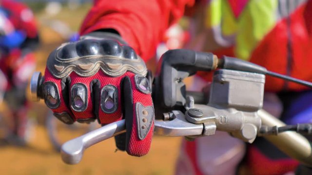 Un piloto de enduro de motocross con un guante rojo acelera su motocicleta antes de abandonar el circuito en Valencia