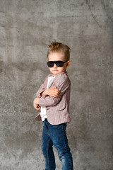 Image of cheerful excited little boy child standing isolated over concrete wall.