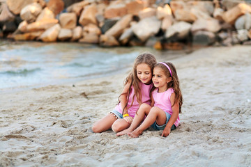 two little sisters having fun at the beach