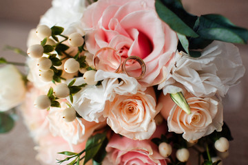 Pale pink bridal bouquet with delicate pink flowers with rings.