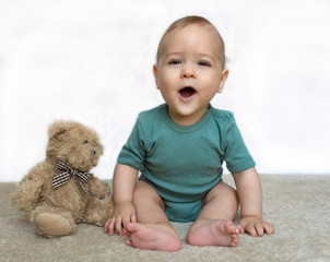 Sweet little baby boy with teddy bear on white background