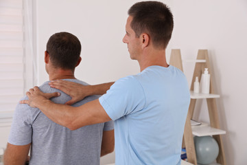 Obraz premium Chiropractic treatment, Back pain relief. Physiotherapy / Kinesiology for male patient, sport injury recovery
